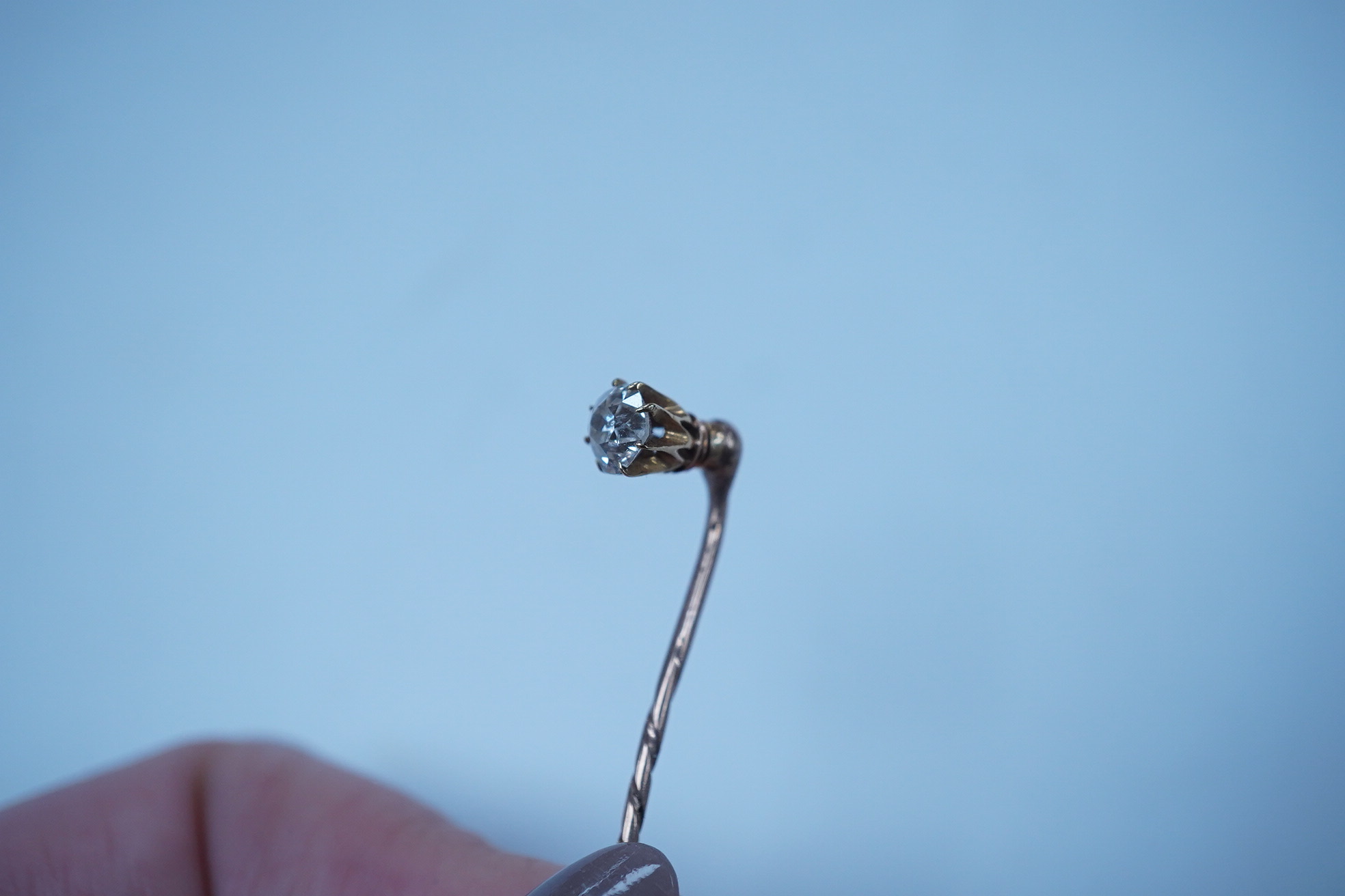 A yellow metal and solitaire diamond set stick pin, the stone diameter approx. 5mm, 59mm, gross weight 2.3 grams. Condition - fair to good